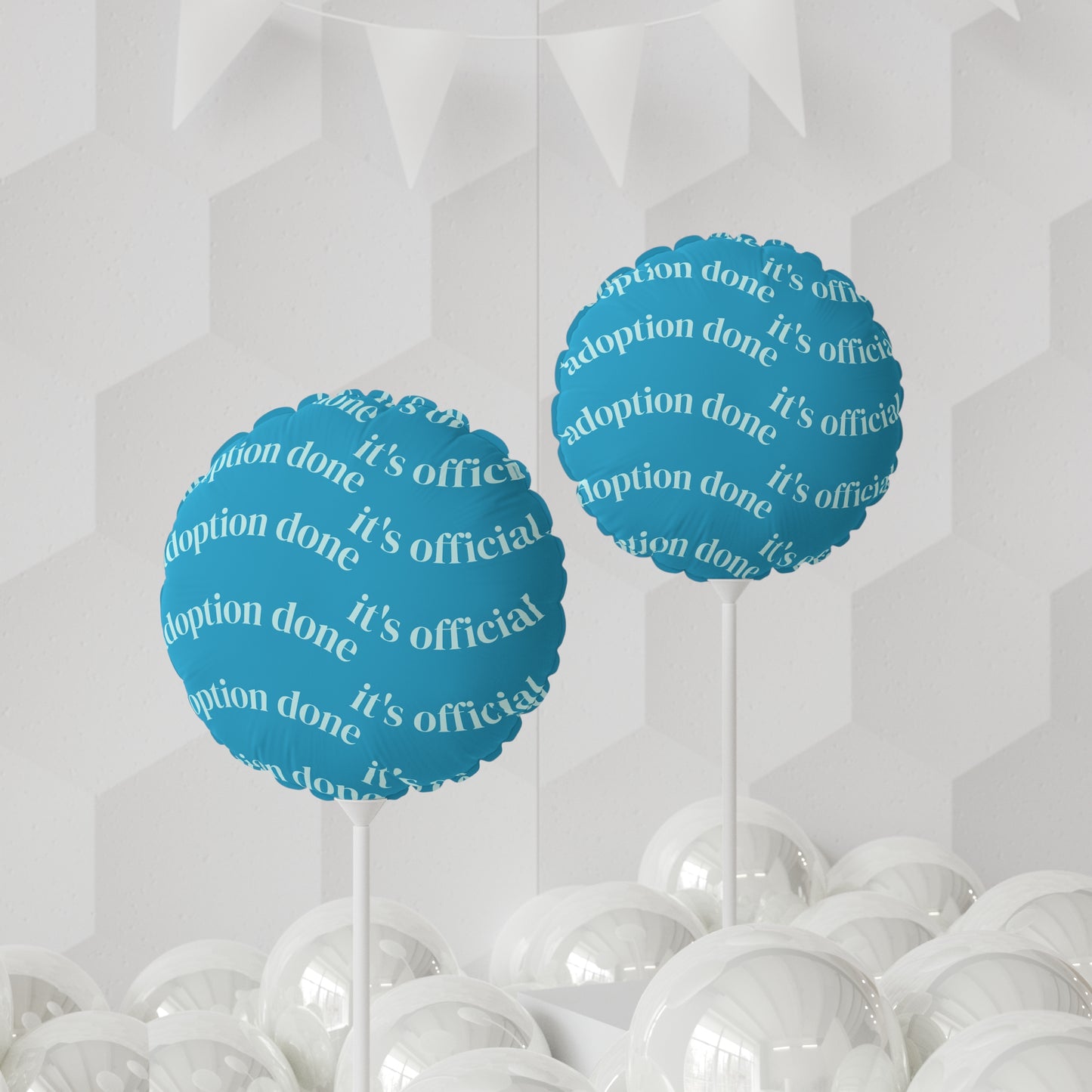 Blue balloons with 'adoption done, it's official!' text on a white background